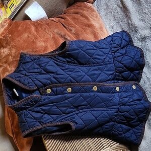 Navy blue ski jacket trimmed in brown with gold buttons
